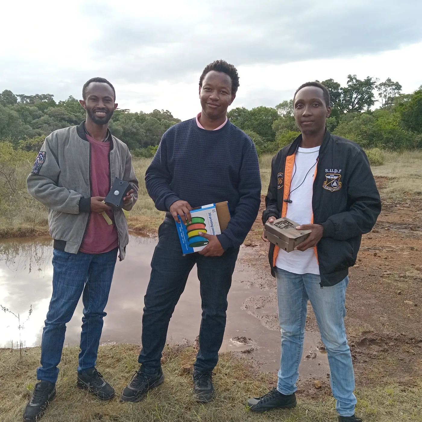 Three of the team with a camera trap